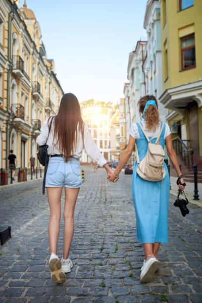 istock Girlfriends hold hands and walk around the city 1170722554