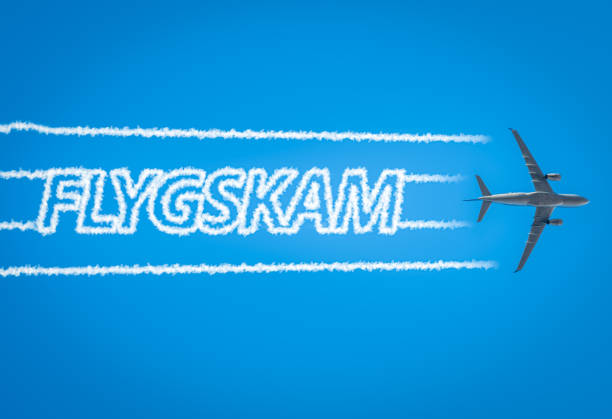 Airplane leaving jet contrails with Flygskam word inside stock photo