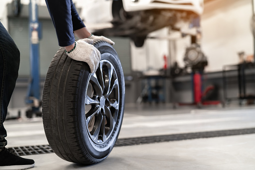 Mechanic man change a wheel tire and service maintenance the suspension of a vehicle , Safety inspection test engine before customer drive a car on a long journey, transportation service