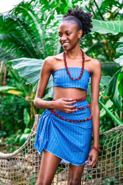 belle fille africaine restant parmi la jungle verte - nigeria african culture dress smiling photos et images de collection