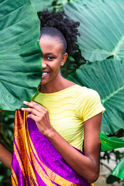 istock African girl hid behind palm leaf and smiles 1170727298