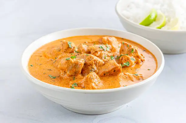 Indian Butter Chicken with Rice, Creamy Indian Chicken Curry DIsh, White Background, Indian Food Photography.