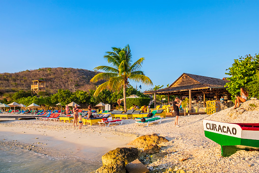 Tourists relaxing on Playa PortoMari, a beautiful sandy bay with a popular snorkel and dive site located on the west coast of Curaçao, an island in the southern Caribbean Sea.