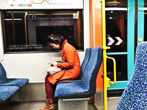 pasajeros (incluido un turista chino) sentados en un colorido tren u-bahn que sale de frankfurt am main hauptbahnhof (estación central de frankfurt) - alemania - information symbol audio fotografías e imágenes de stock