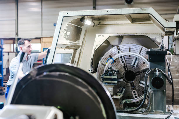 istock Worker operating a CNC lathe in factory 1170733413