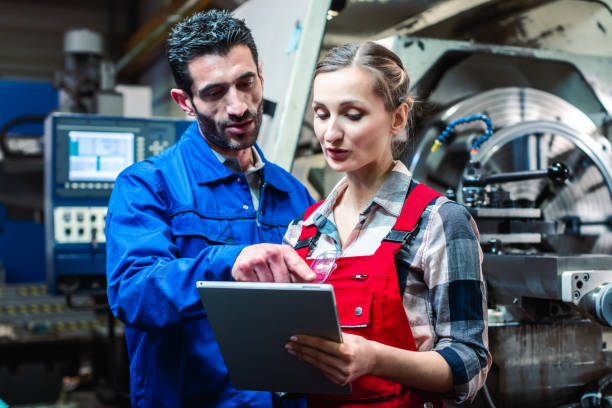 istock Woman and man manufacturing worker in discussion 1170733573