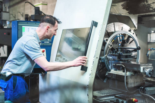 istock Worker operating a CNC lathe in factory 1170734181