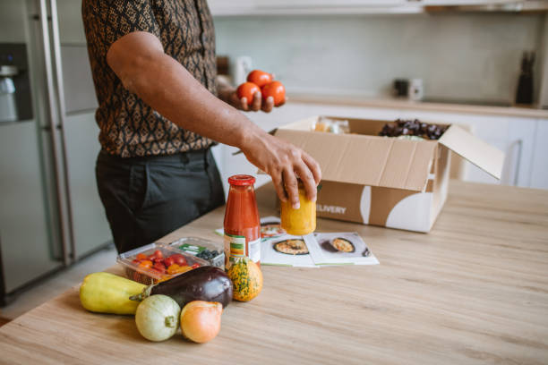 istock Latin Man Opening Parcel With Meal Kit 1170736650