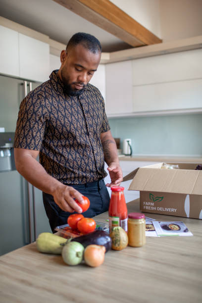 istock Latin Man Opening Parcel With Meal Kit 1170736676