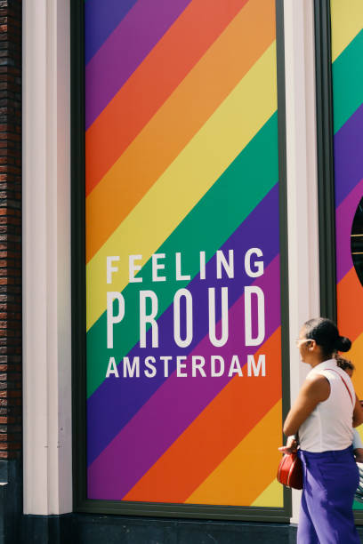 amsterdam, niederlande, juli 2019:schaufenster mit lgbt-flaggenfarben, gefühl stolze inschrift, menschen unterschiedlichen alters, nationalitäten gehen vorbei, amsterdam ist tolerant und multinationale stadt - city amsterdam urban scene gay parade stock-fotos und bilder