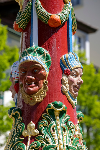 Lucerne, Switzerland - May 06, 2016: Colorful grotesque figures it is a detail on a pillar of Fritschi Fountain in Gothic style. A variety of fountains is a great tourist attraction in the City. The city of Lucerne is one of the countless wonderful places in Switzerland and a tourist attraction visited by many tourists from all over the world.