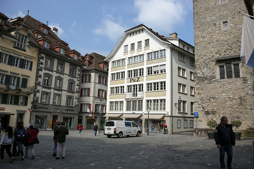 Lucerne, Switzerland - May 02, 2016: Buildings at the nice square in the old town called Kornmarkt looks to be tuned with modern times and offers variety of sightseeing attractions. The city of Lucerne is one of the countless wonderful places in Switzerland and a tourist attraction visited by many tourists from all over the world.