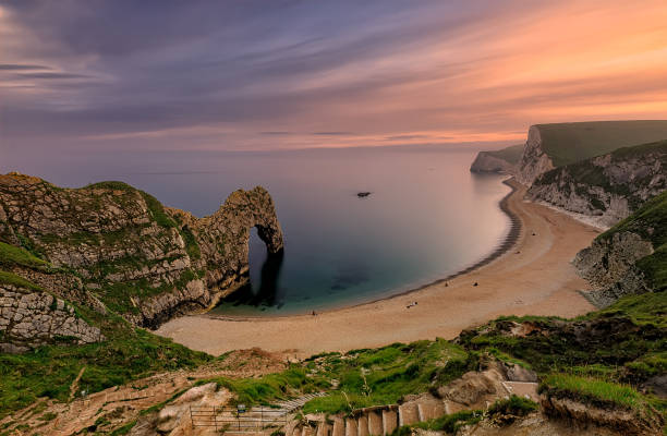 The Durdle Door rock arch on the Dorset Coast of Jurassic coast at sunset. The Durdle Door rock arch on the Dorset Coast of Jurassic coast at sunset. Southern England. North Sea, UK durdle door stock pictures, royalty-free photos & images