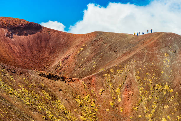 A group of people standing on the edge of the volcano crater, Mount Etna, Sicily, Italy stock photo