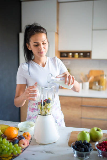 istock Smiling woman making smoothie 1170747168