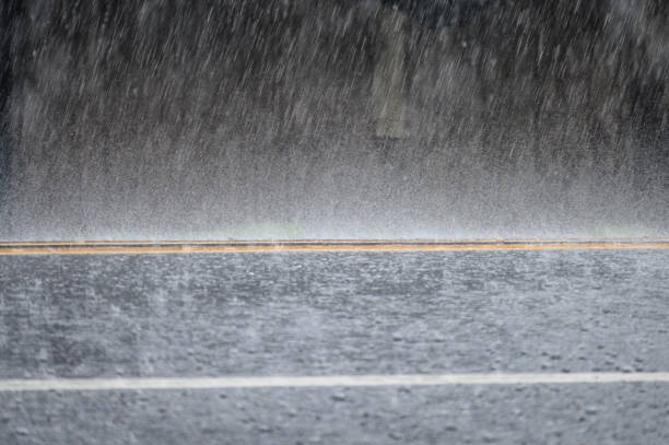 tormenta de lluvia en la carretera - single line yellow road asphalt fotografías e imágenes de stock
