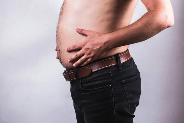 Photo of Man touching his fat belly on white background - Man fat overweight show belly
