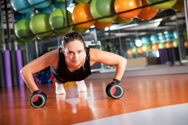 istock Young Woman Doing Push-Ups on Gym Floor 1170747580