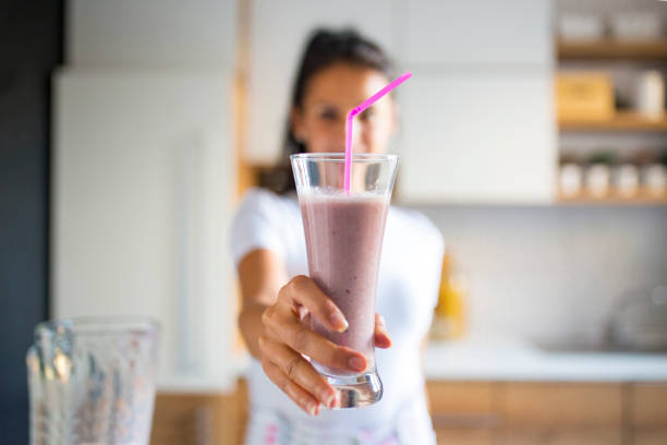 istock Smiling woman drinking smoothie 1170747904