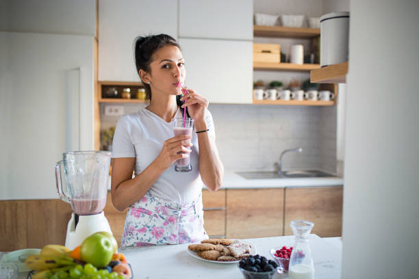 istock Smiling woman drinking smoothie 1170748479