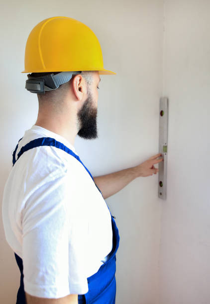 istock Construction worker and handyman is working on renovation of apartment. Builder is measuring and checking wall room using leveler tool and spirit level tool at construction site. Renovation concept. 1170750969
