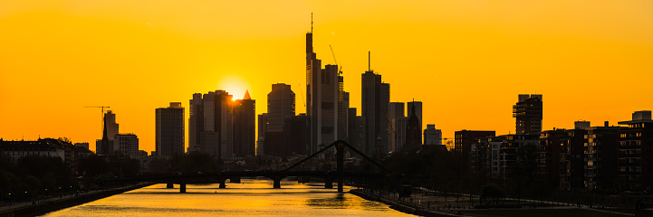Golden sunset on the futuristic skyscraper skyline of Frankfurt above the bridges of the River Main, Hesse, Germany.