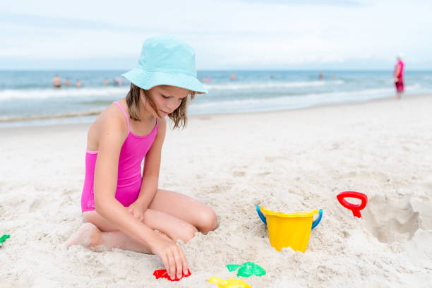 istock Happy child playing with sand at the beach in summer 1170753176