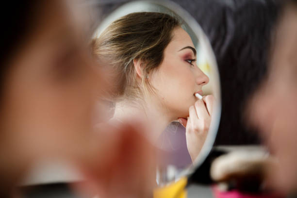 istock Mirror reflection of young woman getting her make up done 1170755436
