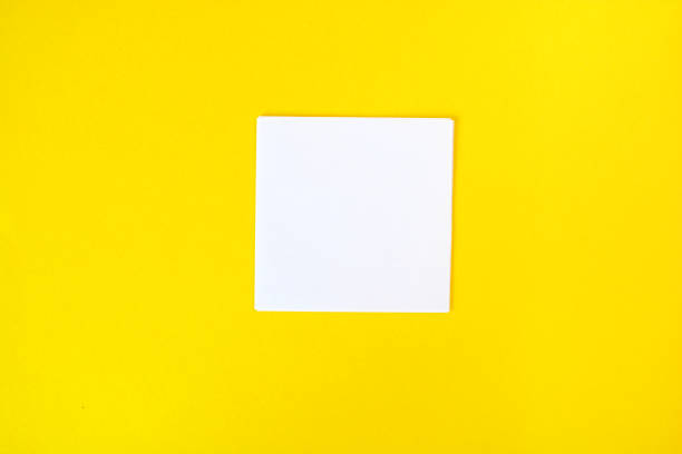 istock Empty white paper on a yellow background, as mockup for your design. Minimal composition in flat lay style. 1170755855