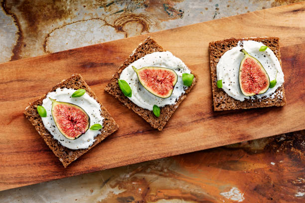 istock Fresh figs with ricotta cheese, fresh basil on rye bread, overhead view. 1170756941