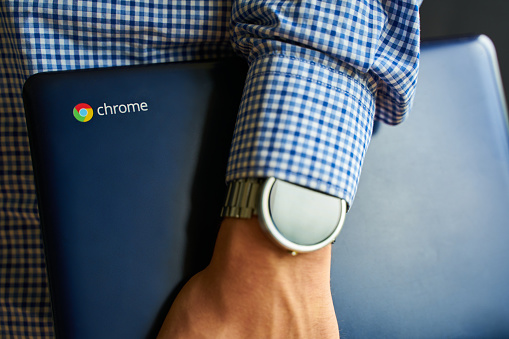 Bishkek, Kyrgyzstan - June 6, 2019: Asus Chromebook in man's hand with watch on it.