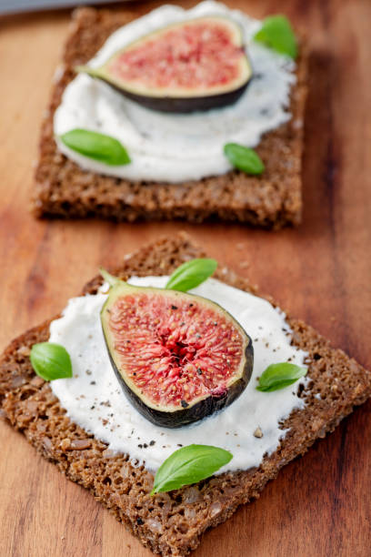 istock Fresh figs with ricotta cheese, fresh basil on rye bread, overhead view. 1170757115