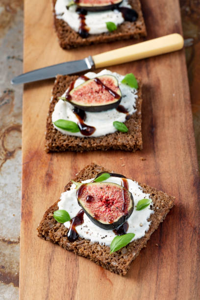 istock Fresh figs, ricotta cheese, fresh basil on rye bread with balsamic vinegar overhead view. 1170757172