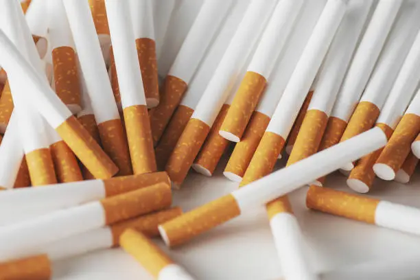 Photo of Close up of a smoking cigarettes . cigarette filter tubes
