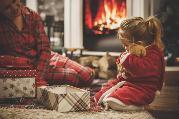 Photo of Little girl hugging her new teddy bear on a Christmas Eve