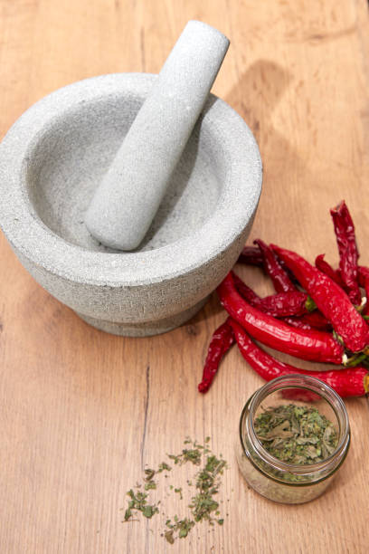 istock mortar and pestle with herbs and chili on kitchen board 1170760933