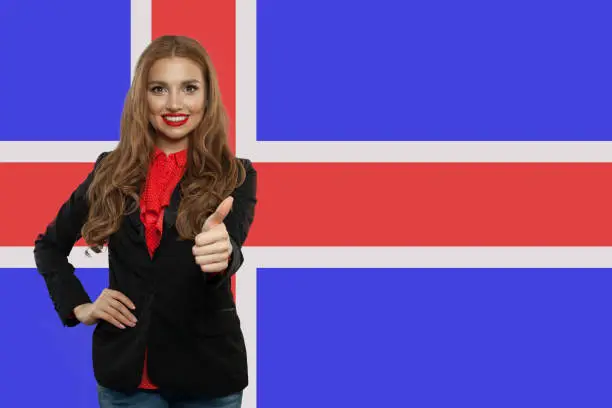 Iceland concept with cute happy woman against the Icelandic flag background. Travel and learn Icelandic language