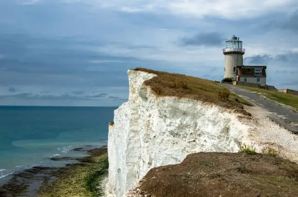 Iconic view of a lighthouse on a chalk cliff by the sea, England