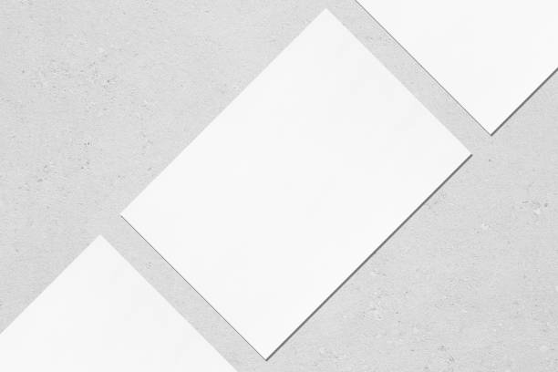 istock Closeup of three empty white rectangle poster mockups lying diagonally on grey concrete background 1170767916