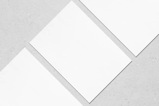 istock Close up of three empty white rectangle poster mockups lying diagonally on grey concrete background 1170767918