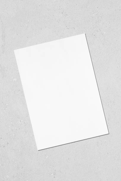 white vertical rectangle poster mockup lying diagonally on grey concrete background