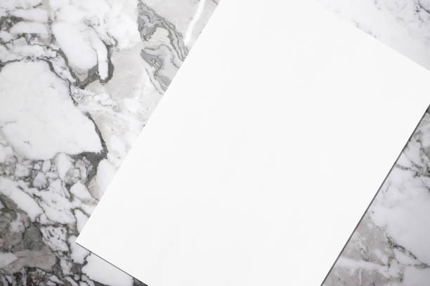 istock Close up of empty white rectangle poster mockup lying diagonally on grey marble background 1170767963