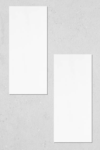 istock Two empty white vertical rectangle price-list or menu mockups lying on grey concrete background 1170767977