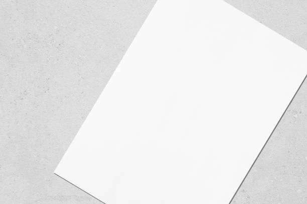 istock Close up of empty white rectangle poster mockup lying diagonally on grey concrete background 1170767998