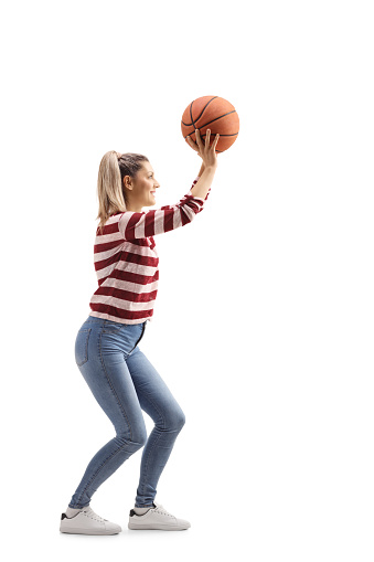 Una joven casual disparando un baloncesto photo