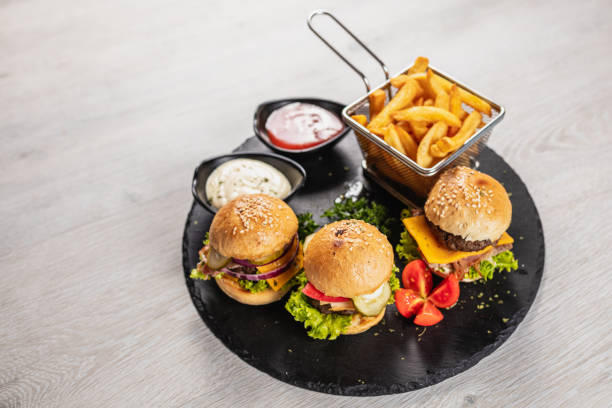 Three delicious mini burgers served on a granite board