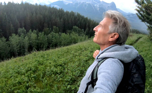 istock Man hikes above forest in mountains as storm approaches 1170773913