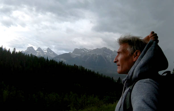 istock Man hikes above forest in mountains as storm approaches 1170773943