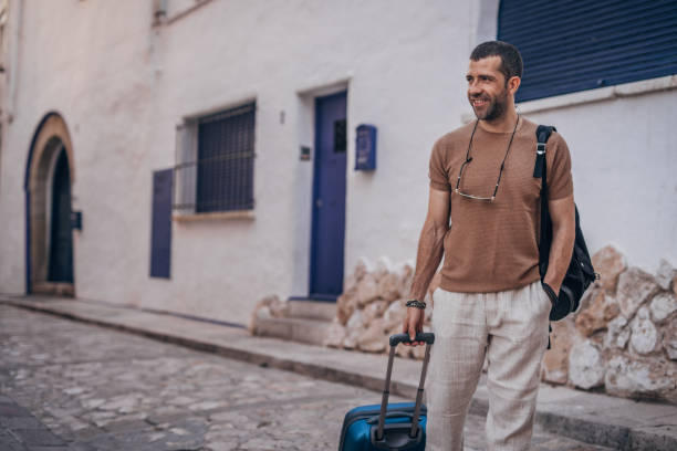 istock Man with luggage standing on the street 1170774061