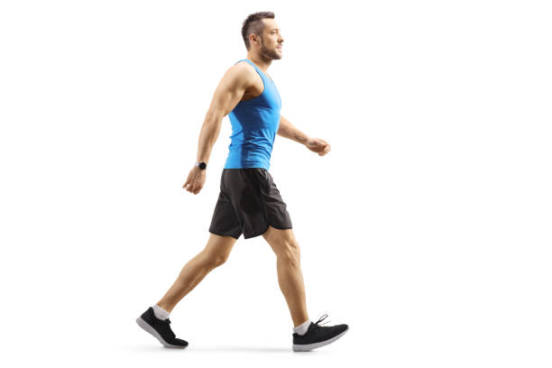 Full length profile shot of a sportsman walking isolated on white background